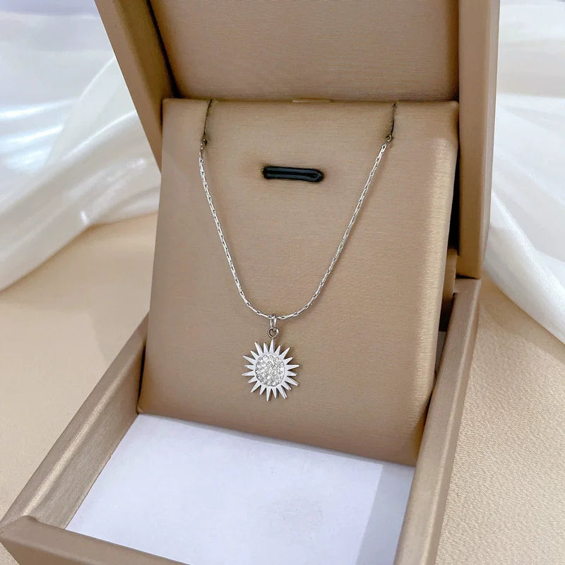 Collier en or avec pendentif fleur, zircone incrustée, chaîne en acier titane et pendentif soleil en opale (1 pièce).
