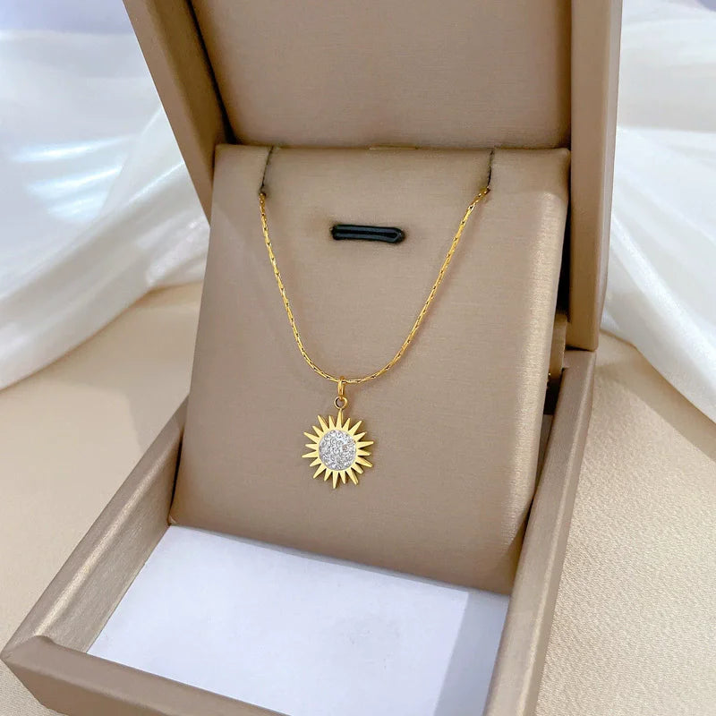 Collier en or avec pendentif fleur, zircone incrustée, chaîne en acier titane et pendentif soleil en opale (1 pièce).